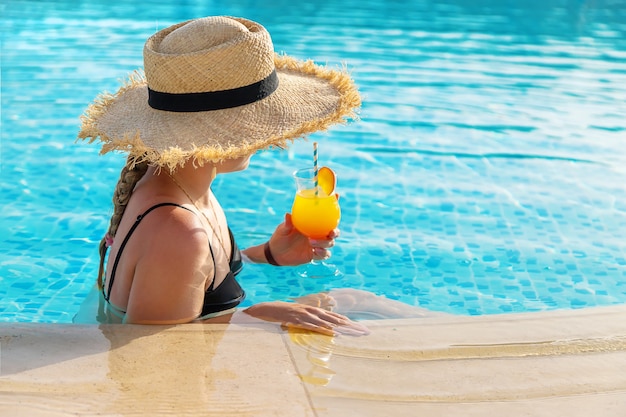 Donna con cocktail in piscina