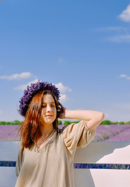 Donna con corona di fiori nel campo di lavanda