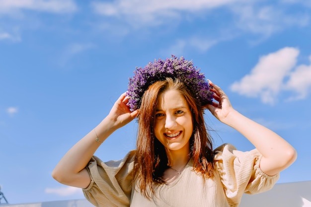 Donna con corona di fiori nel campo di lavanda