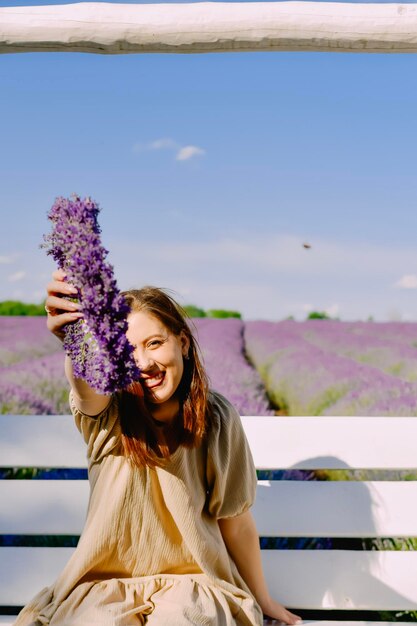 Donna con corona di fiori nel campo di lavanda