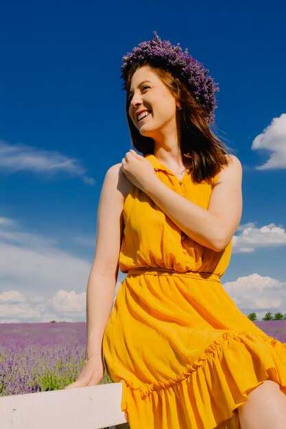 Donna con corona di fiori nel campo di lavanda