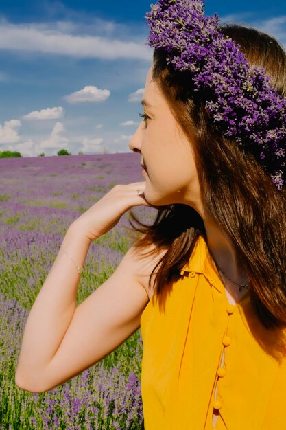 Donna con corona di fiori nel campo di lavanda