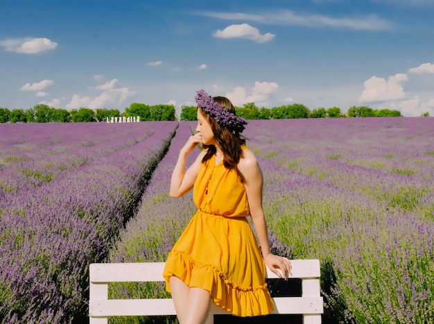 Donna con corona di fiori nel campo di lavanda