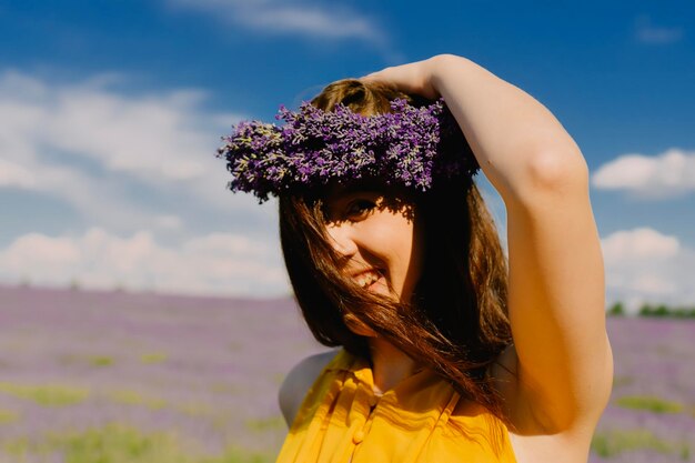 Donna con corona di fiori nel campo di lavanda