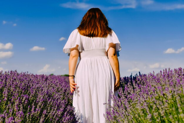 Donna con corona di fiori nel campo di lavanda