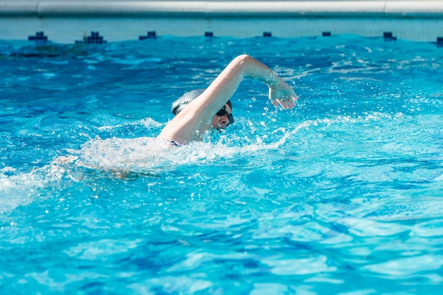 Donna con cuffia e occhiali per nuotare in una piscina