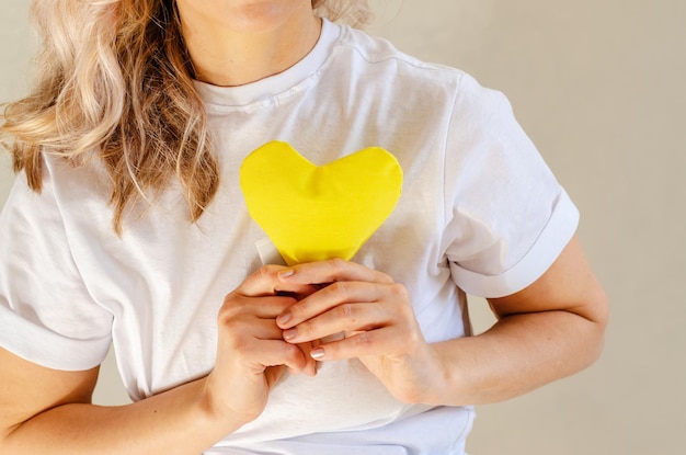 Donna con cuore giallo Concetto di consapevolezza dell'amore giallo settembre