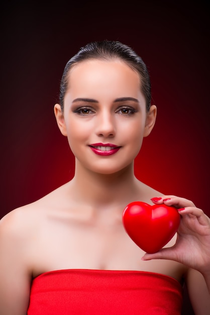 Donna con cuore rosso nel concetto romantico