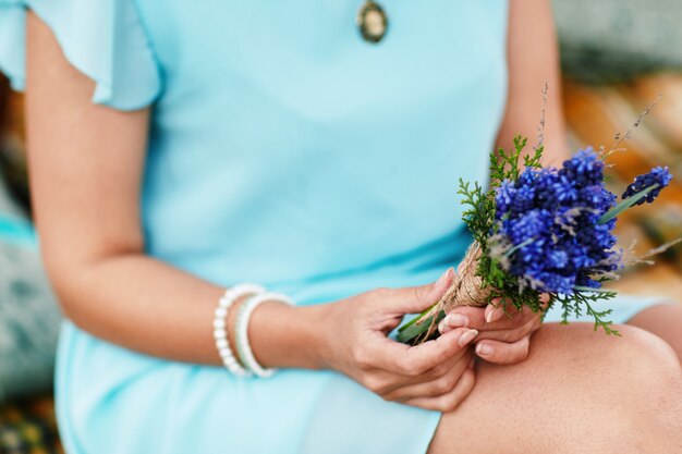 Donna con elegante bouquet di fiori blu