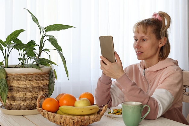 Donna con frutta a tavola