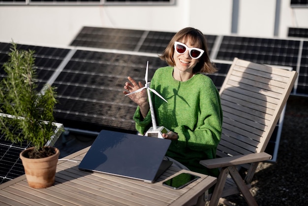 Donna con generatore eolico giocattolo sul tetto con impianto solare