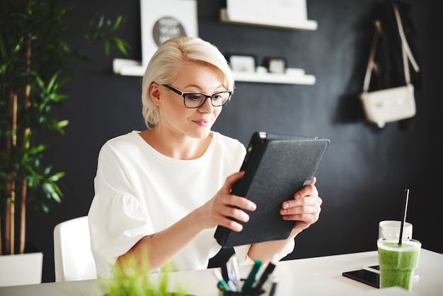 Donna con gli occhiali che utilizza una tavoletta digitale