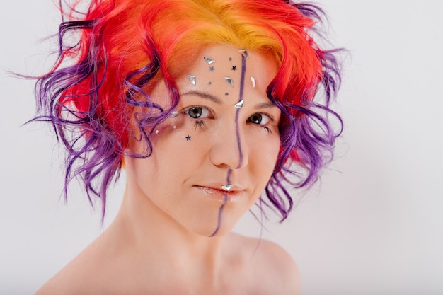 Donna con i capelli colorati. Ragazza con trucco e acconciatura