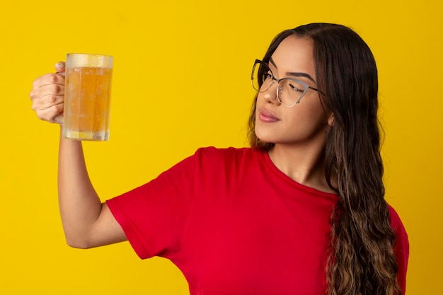 donna con i capelli lunghi e ricci che indossa occhiali e tiene un bicchiere di birra fredda