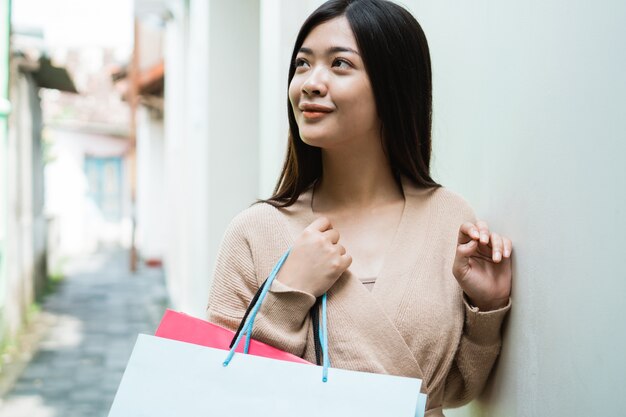 Donna con i sacchi di carta che gode della compera