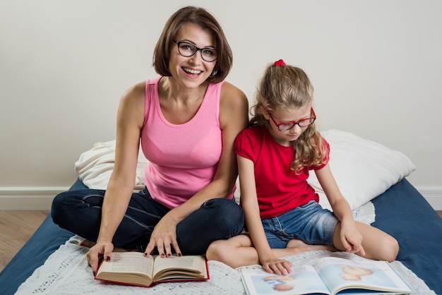 Donna con il bambino della figlia che legge insieme