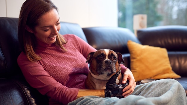 Donna Con Il Braccio Protesico E La Mano A Casa Con Il Cane