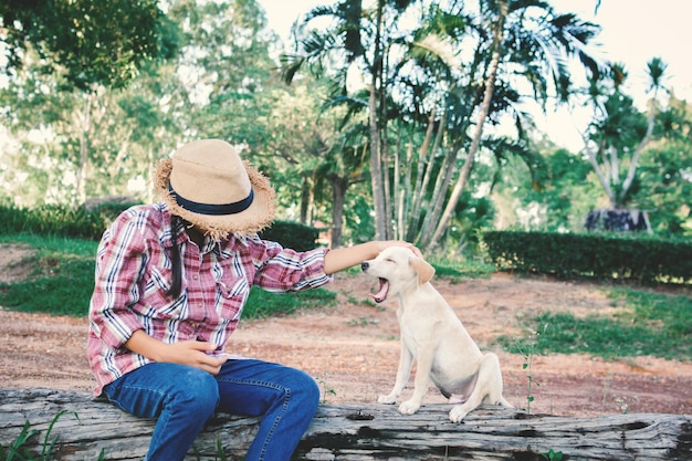 Donna con il cane seduta contro gli alberi