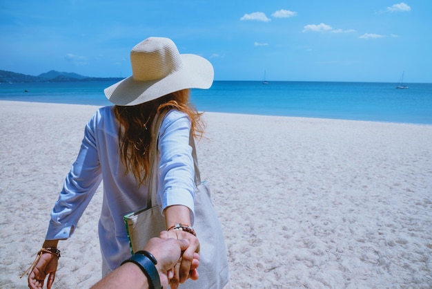 Donna con il cappello sulla spiaggia contro il mare