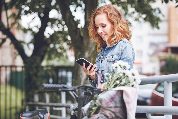 Donna con il cellulare che si rilassa dopo la bicicletta