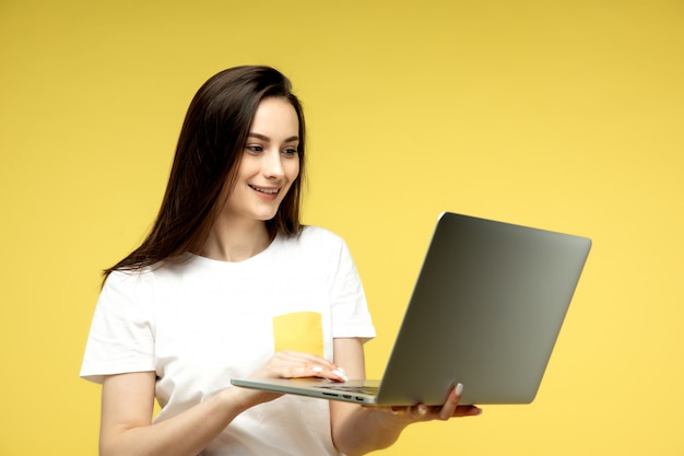 donna con il portatile su sfondo giallo
