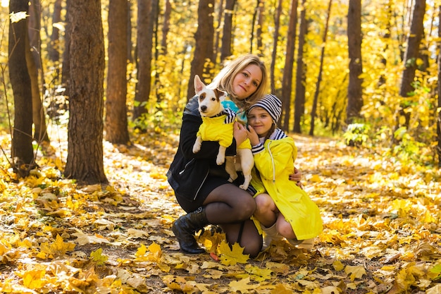 Donna con il suo cane al parco d'autunno.