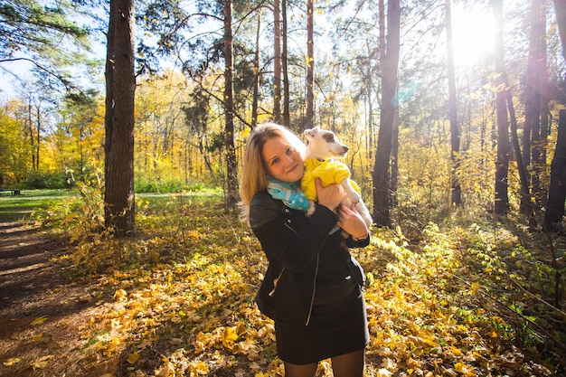 Donna con il suo cane al parco d'autunno.