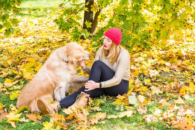 Donna con il suo cane da riporto nel parco in autunno