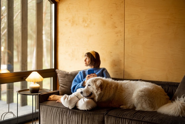 Donna con il suo cane in casa di legno sulla natura