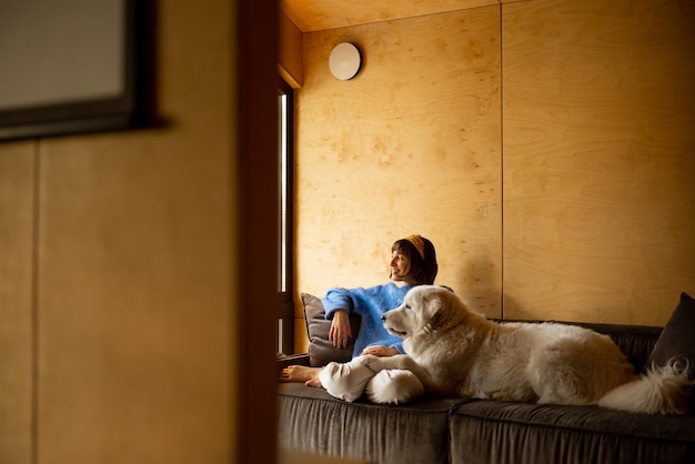 Donna con il suo cane in casa di legno sulla natura