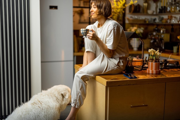 Donna con il suo cane in cucina durante una mattinata