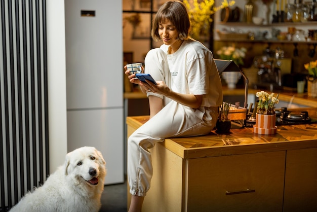 Donna con il suo cane in cucina durante una mattinata