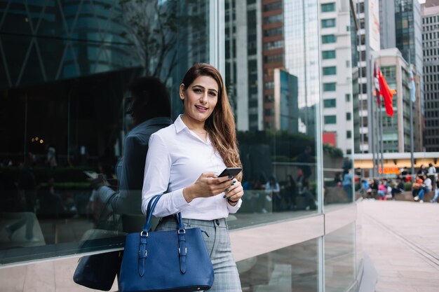 Donna con il telefono fuori dall'edificio per uffici