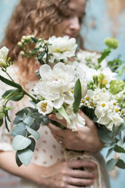 Donna con in mano un mazzo di fiori bianchi