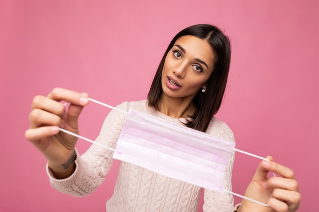 Donna con in mano una maschera di protezione antivirus