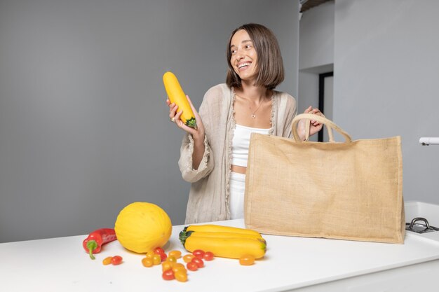 Donna con ingredienti alimentari crudi in cucina moderna a casa