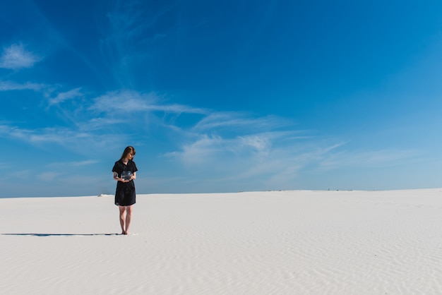 Donna con l'acquario a piedi nel deserto