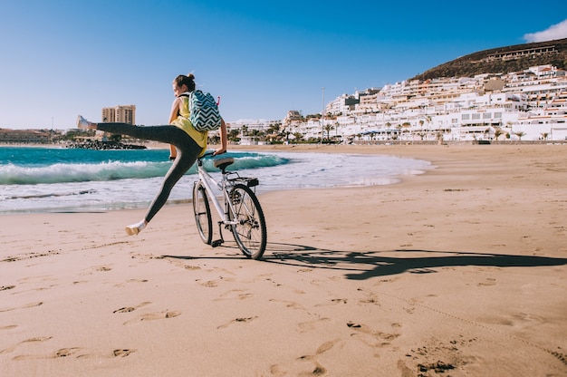 Donna con la bicicletta in spiaggia