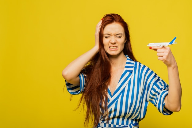 Donna con la faccia arrabbiata che tiene un aeroplano