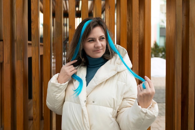 Donna con la giacca bianca e i capelli blu.