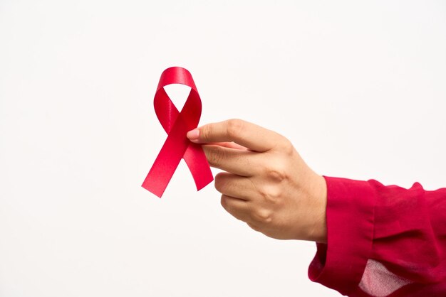 Donna con la mano che tiene il nastro rosso della Giornata Mondiale dell'AIDS