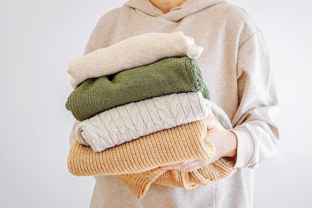 Donna con la mano che tiene una pila di vestiti donazione di vestiti concetto rinnovabile donazione lavatura di scatole