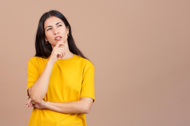 Donna con la mano sul viso e l'espressione pensierosa