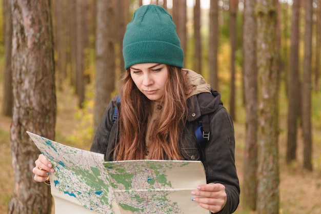 Donna con la mappa di viaggio e zaino in abetaia