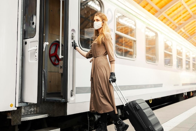 Donna con la maschera che entra nel treno