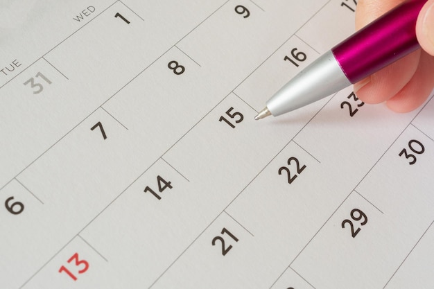 donna con la penna in mano con la pagina del calendario
