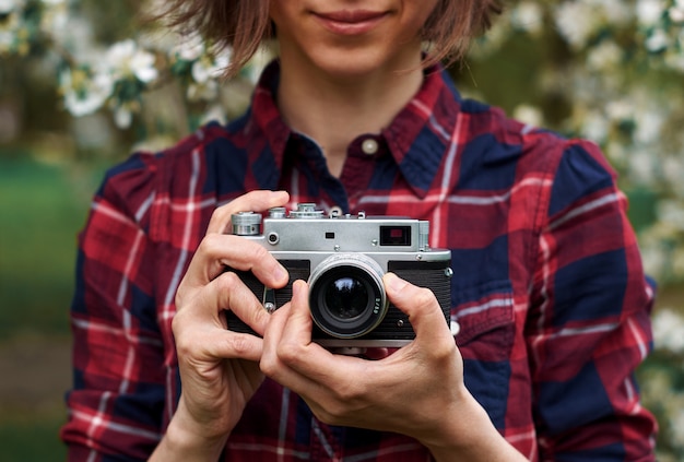 donna con la retro macchina fotografica che prende foto all'aperto