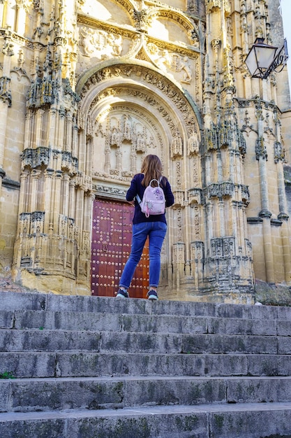 Donna con la schiena che contempla l'imponente facciata della cattedrale di Arcos de la Frontera Cadice
