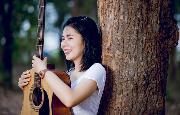 Donna con la sua chitarra che canta in natura