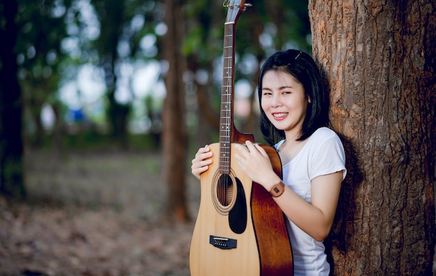 Donna con la sua chitarra che canta in natura